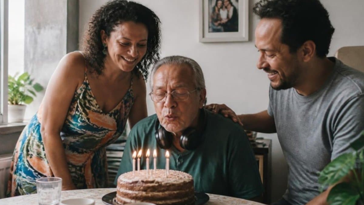 Autismo e expectativa de vida: homem de 65 anos com fones no pescoço assopra velas de aniversário ao lado dos filhos adultos